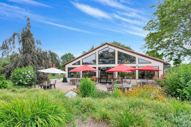 a view of a swimming pool with a table and chairs under an umbrella