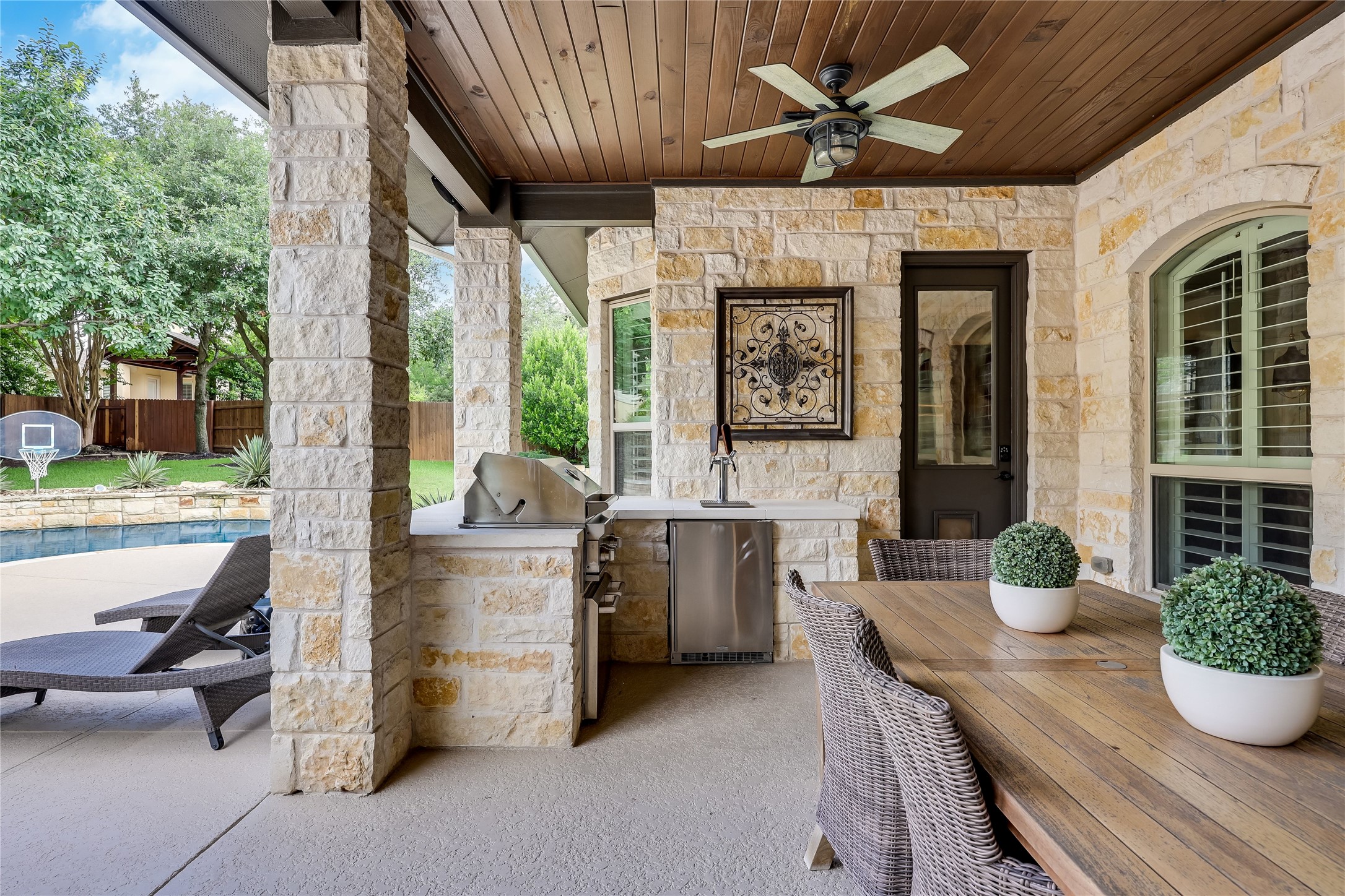 401 Bluff View Road Cedar Park, TX 78613 - Photo 4 of 40 An inviting covered patio featuring a built-in outdoor kitchen and a sparkling pool beyond.