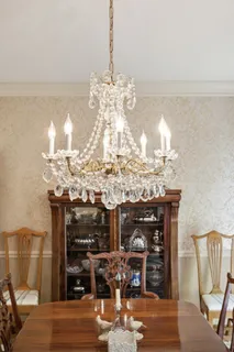a view of a dining room with furniture a chandelier and wooden floor