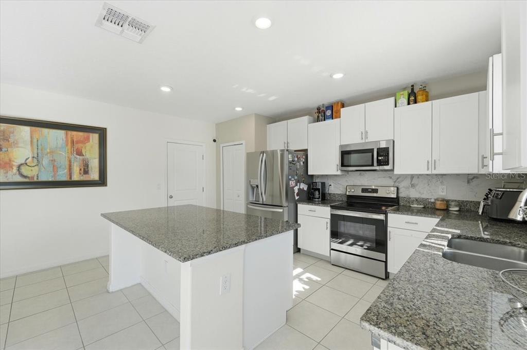 2175 Old Mining Road Lakeland, FL 33801 - Photo 8 of 51 a kitchen with stainless steel appliances granite countertop a sink a stove a microwave and a refrigerator