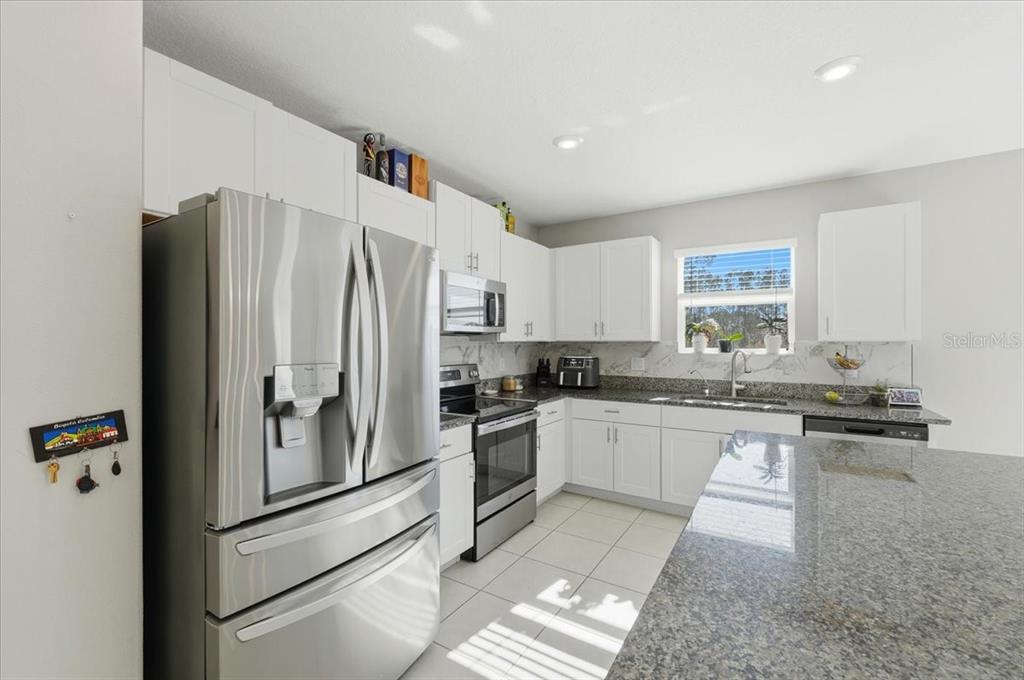 2175 Old Mining Road Lakeland, FL 33801 - Photo 9 of 51 a kitchen with granite countertop a refrigerator stove and sink