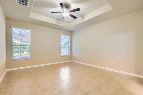 an empty room with windows and fan