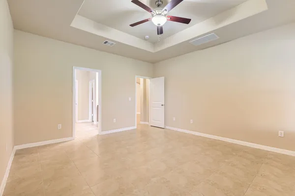 an empty room with chandelier fan