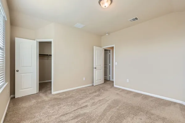 an empty room with closet and bathroom
