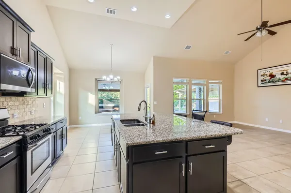 a kitchen with granite countertop cabinets a sink a window and stainless steel appliances