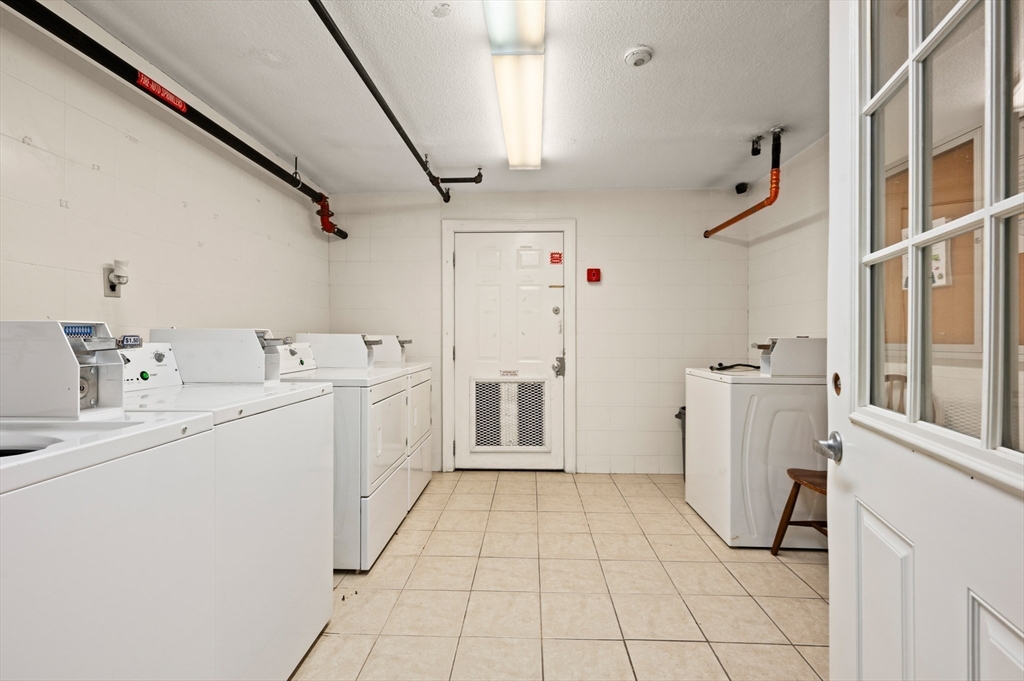 222 Stackpole Street, Unit 4 Lowell, MA 01852 - Photo 12 of 15 a utility room with cabinets washer and dryer