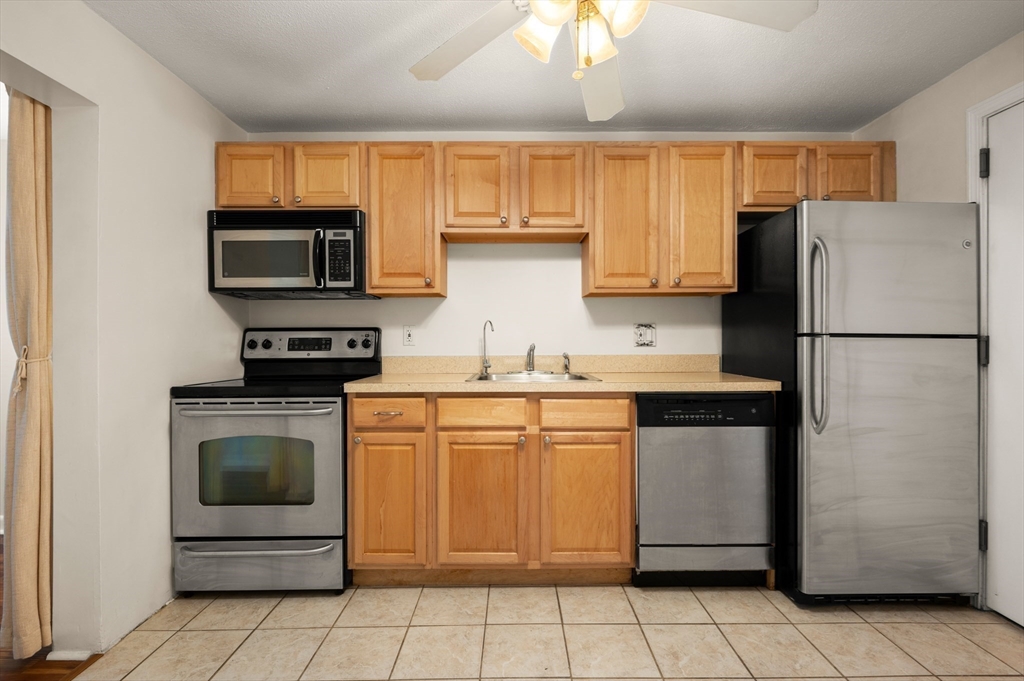 222 Stackpole Street, Unit 4 Lowell, MA 01852 - Photo 4 of 15 a kitchen with granite countertop cabinets stainless steel appliances and a counter space