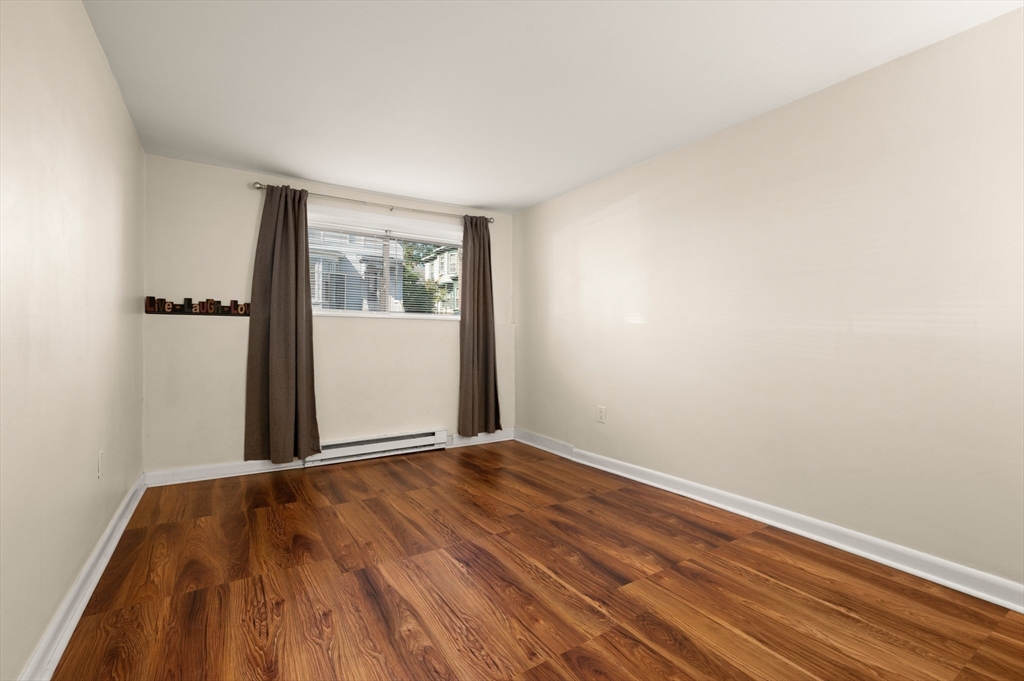 222 Stackpole Street, Unit 4 Lowell, MA 01852 - Photo 8 of 15 a view of an empty room with wooden floor