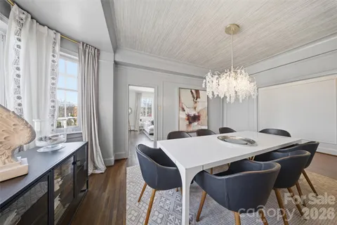 a view of a dining room with furniture a chandelier and wooden floor