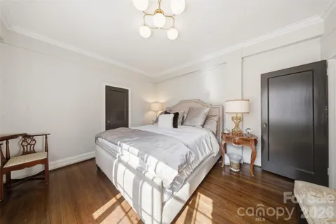 a spacious bedroom with a bed and a flat screen tv