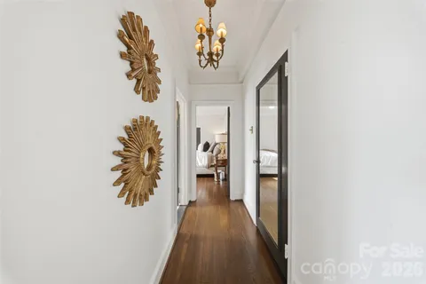 a view of a hallway with wooden floor and furniture