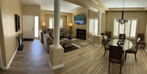 a living room with furniture dining table and wooden floor