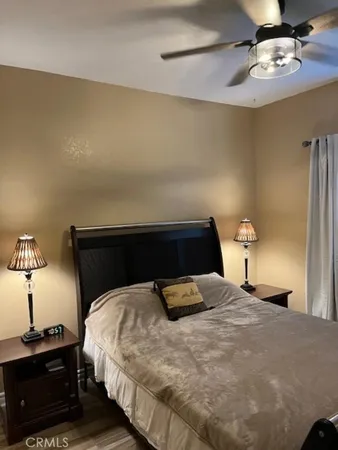a bedroom with a bed and a lamp on dresser