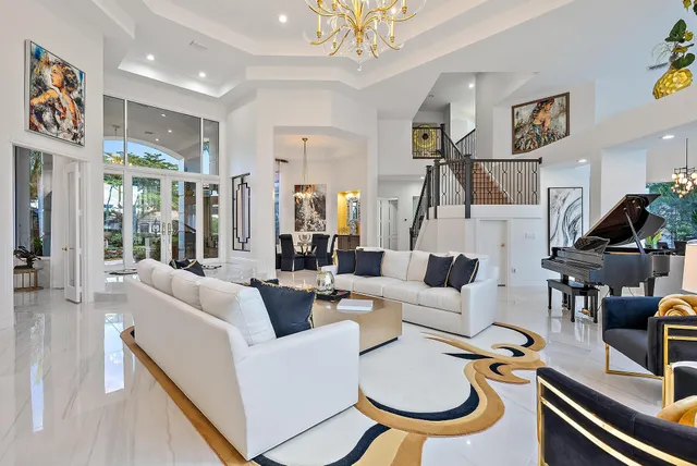 a spacious bedroom with a bed chandelier and a view of living room