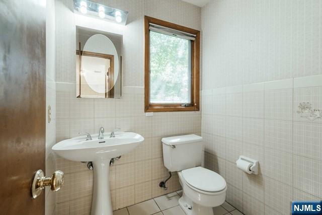 212 Filippe Court Paramus, NJ 07652 - Photo 15 of 16 a bathroom with a toilet sink and mirror