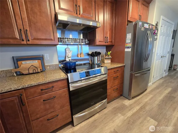 a kitchen with granite countertop stainless steel appliances and wooden cabinets