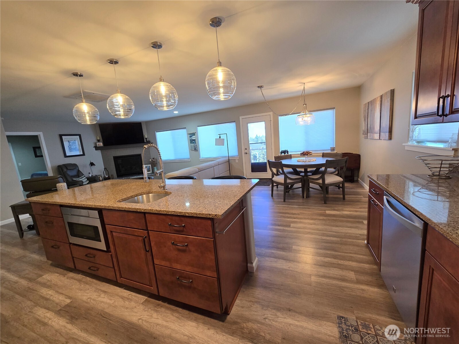 40 Topaz Way Sequim, WA 98382 - Photo 19 of 40 a kitchen with stainless steel appliances granite countertop a stove a sink a oven a dining table and chairs with wooden floor