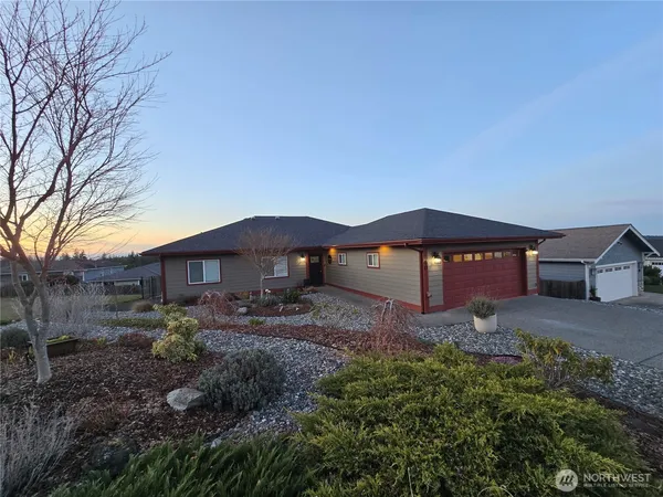 a view of a house with a yard and large tree