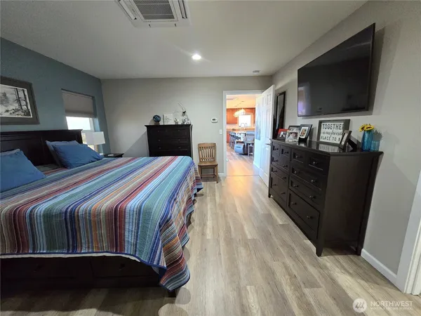 a bedroom with a bed and a flat tv screen on wall