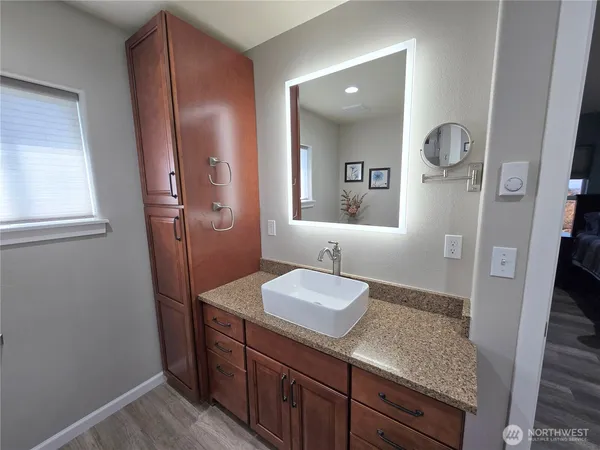 a bathroom with a granite countertop sink and a mirror