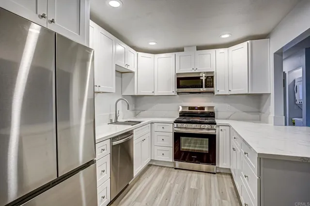 a kitchen with stainless steel appliances granite countertop a stove refrigerator sink and microwave
