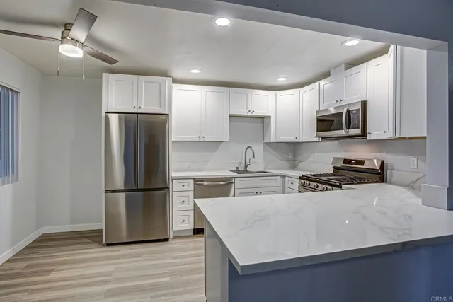 a kitchen with a refrigerator a microwave a sink and wooden floor
