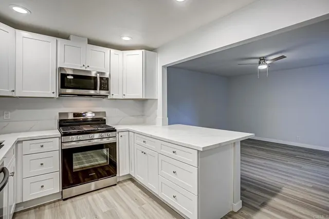 a kitchen with white cabinets and stainless steel appliances