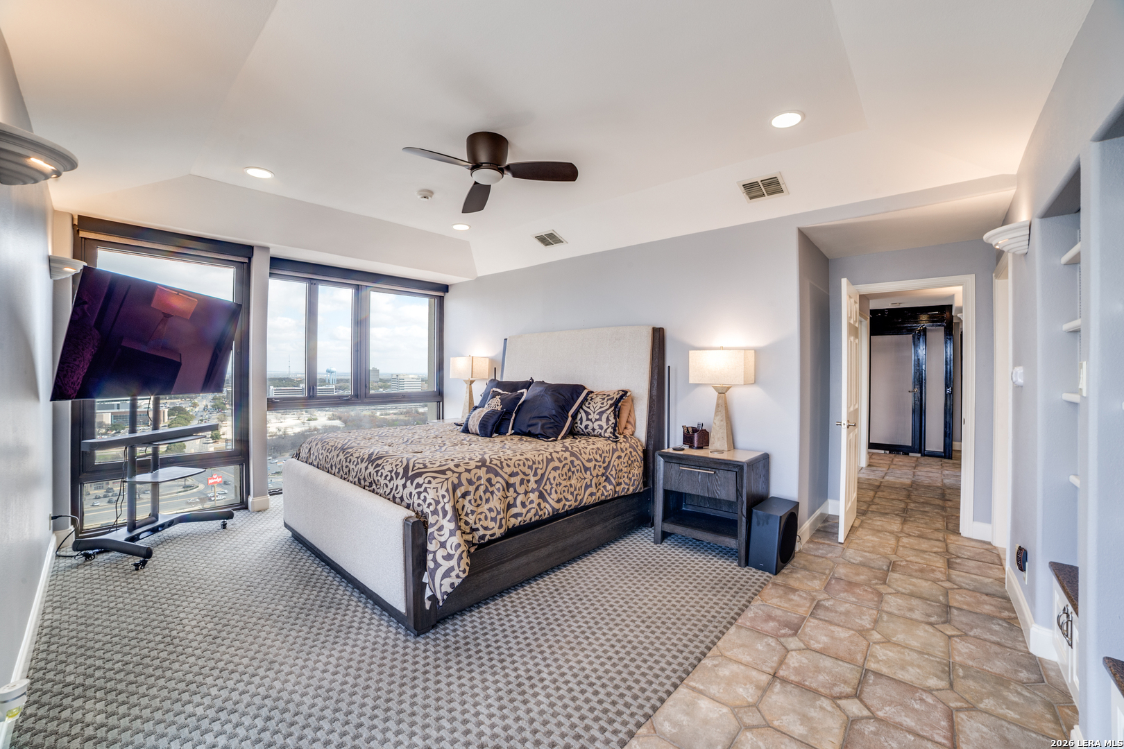 7701 Wurzbach Road, Unit 2303 San Antonio, TX 78229 - Photo 13 of 32 a spacious bedroom with a large bed and a chandelier