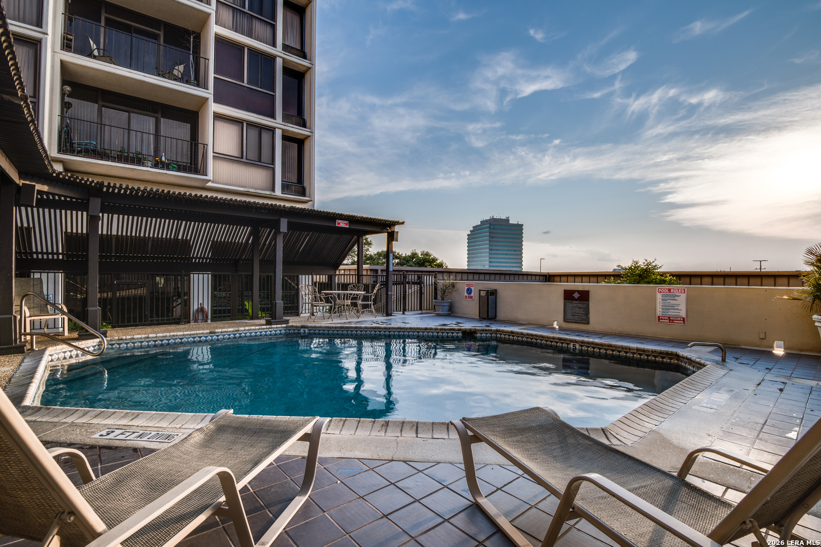 7701 Wurzbach Road, Unit 2303 San Antonio, TX 78229 - Photo 25 of 32 a view of a patio with table and chairs with wooden floor and fence
