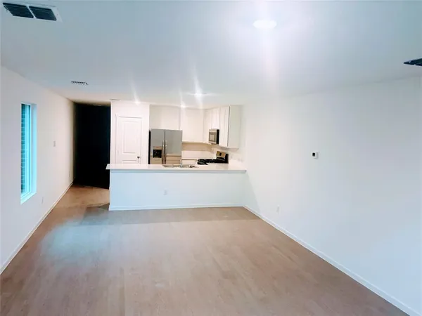 a view of kitchen with kitchen island and stainless steel appliances