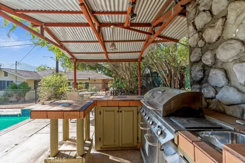 a view of a kitchen with a sink and wooden cabinets