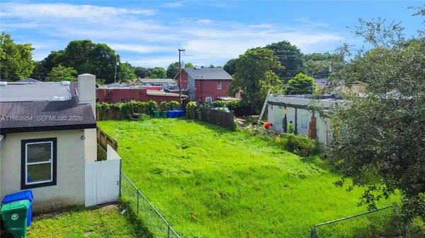 a view of a house with a yard and potted plants