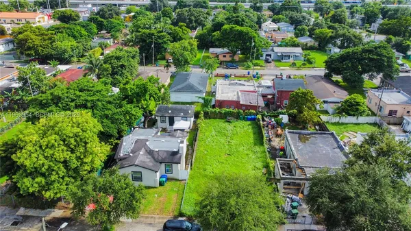 an aerial view of residential houses with outdoor space and trees all around