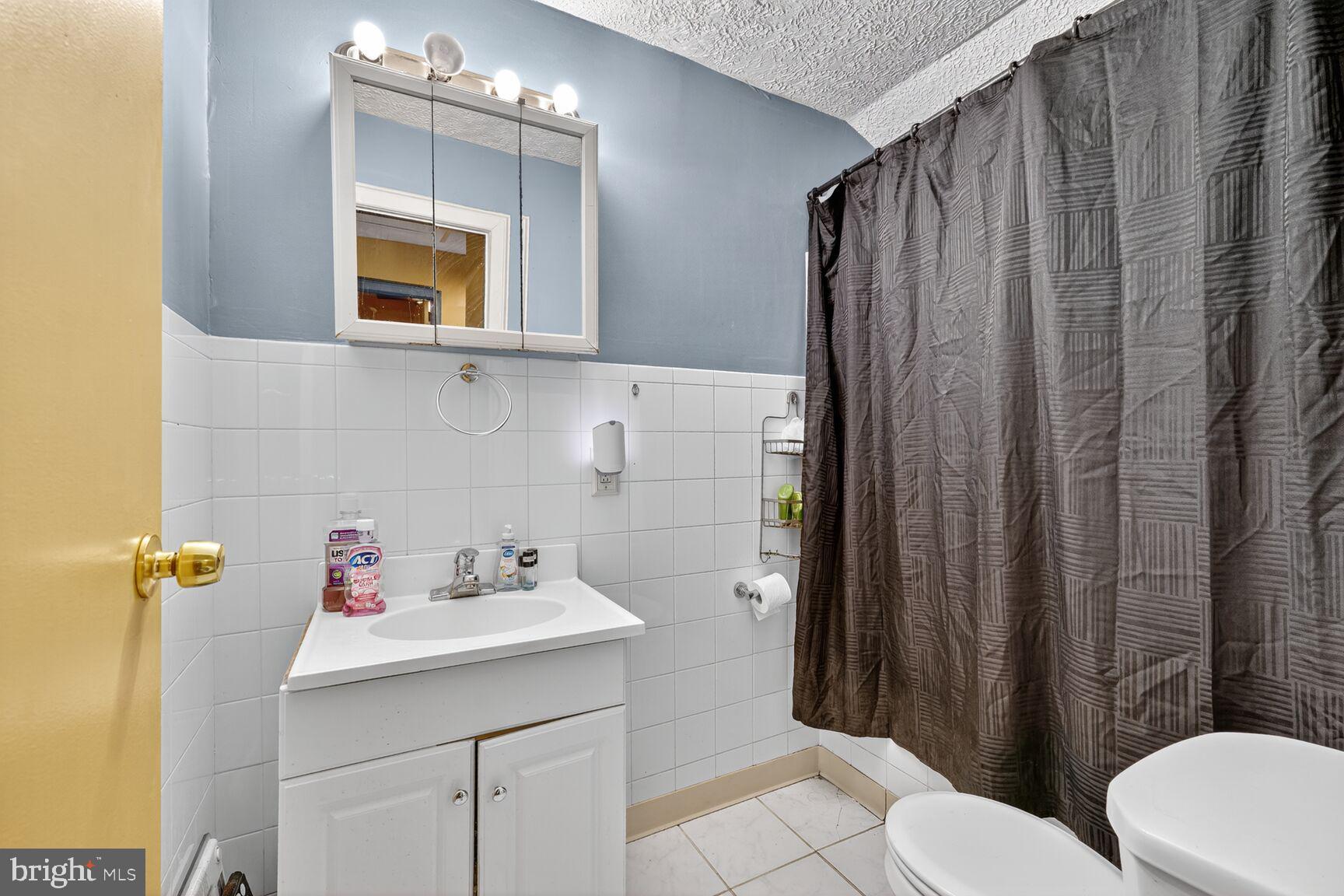 1001 Iago Avenue Capitol Heights, MD 20743 - Photo 6 of 13 a bathroom with a sink a toilet and shower curtain