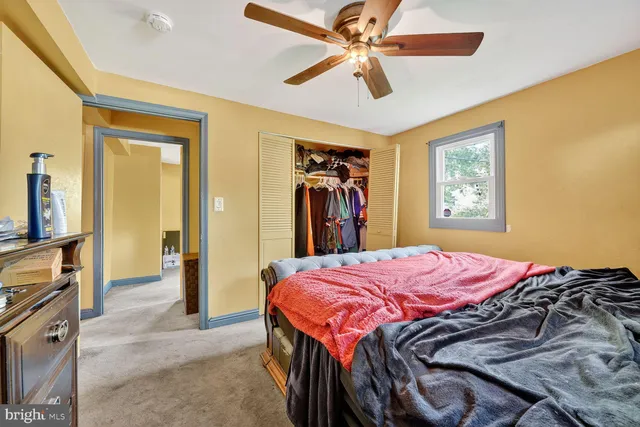 a bedroom with a bed and a flat tv screen on dresser