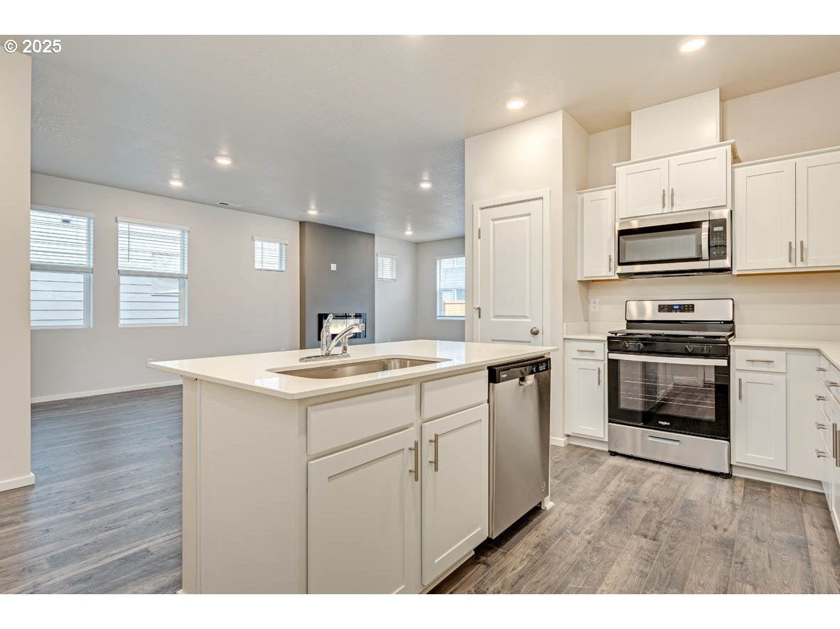 2897 U Street Springfield, OR 97477 - Photo 12 of 26 a kitchen with kitchen island a sink stainless steel appliances and cabinets