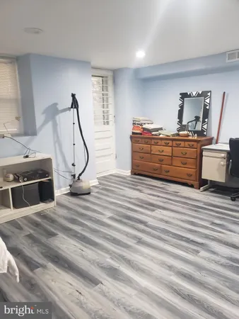 a spacious bedroom with a bed and a dresser