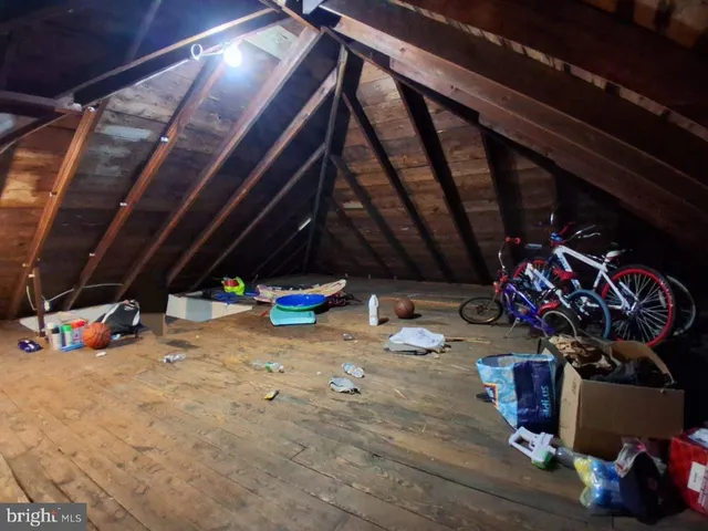 a view of an empty room with wooden floor and windows