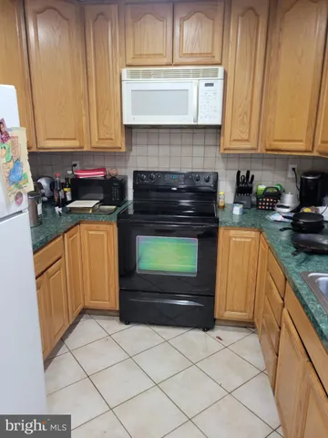 a kitchen with granite countertop a stove top oven and cabinets