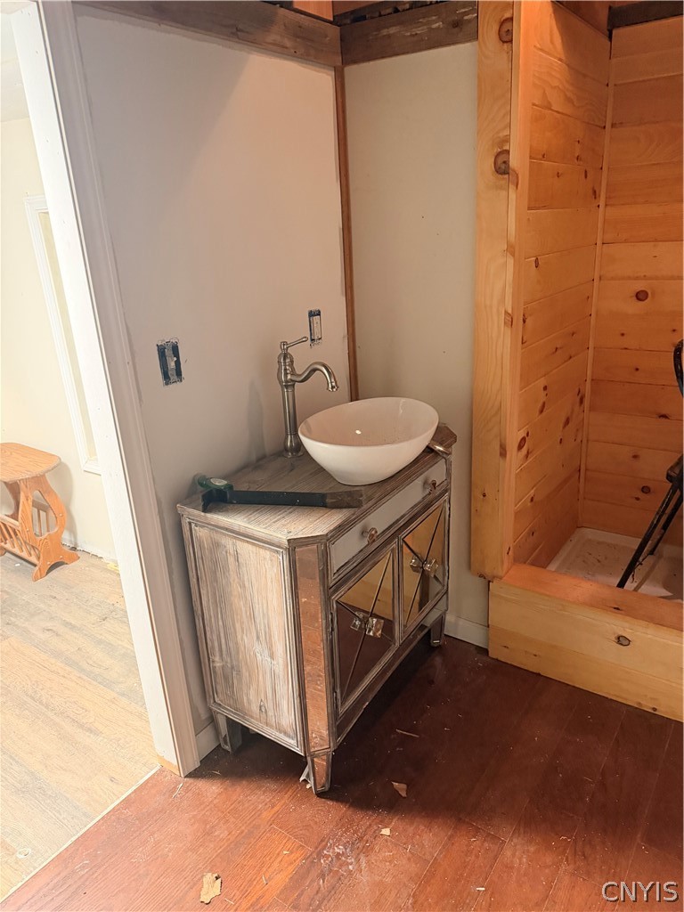 2025 Apulia Road LaFayette, NY 13084 - Photo 13 of 16 A unique vessel sink vanity complements the rich wood flooring and rustic wall paneling.