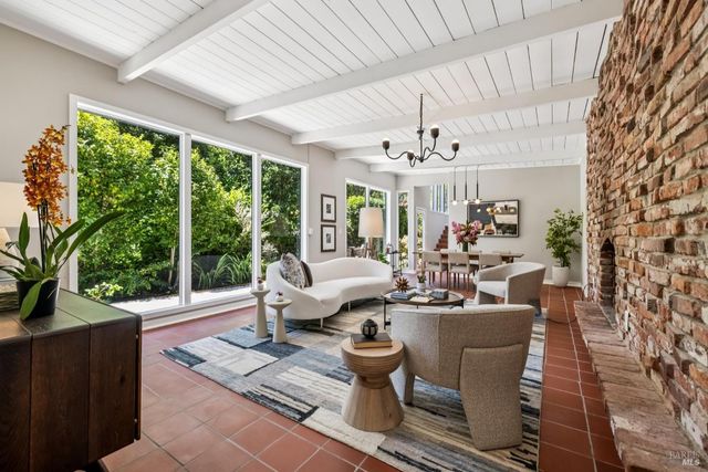 a living room with patio furniture and a chandelier