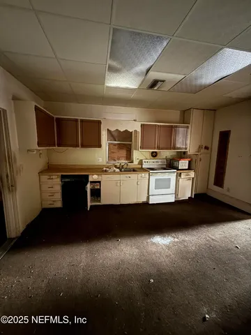 a view of kitchen with microwave a stove and cabinets