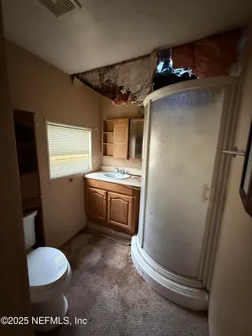 a bathroom with a sink a toilet a mirror and window