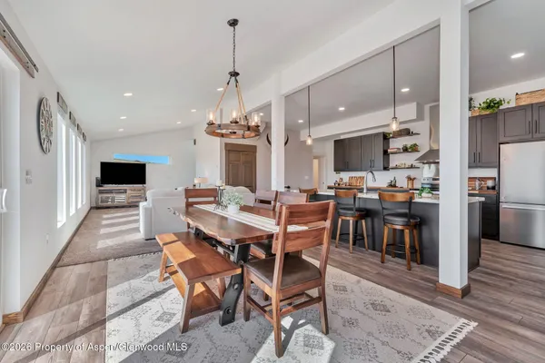 a kitchen with stainless steel appliances kitchen island granite countertop a table chairs sink and cabinets