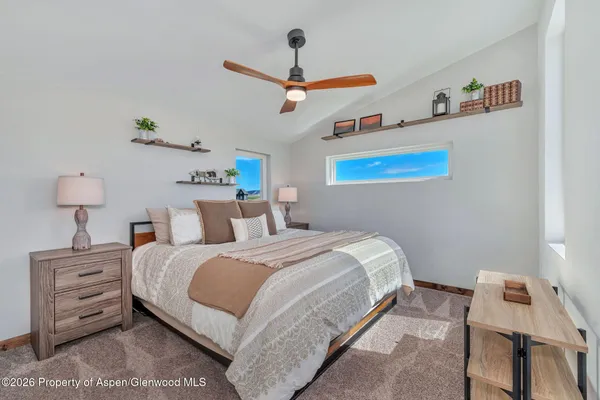 a bedroom with a bed and a ceiling fan