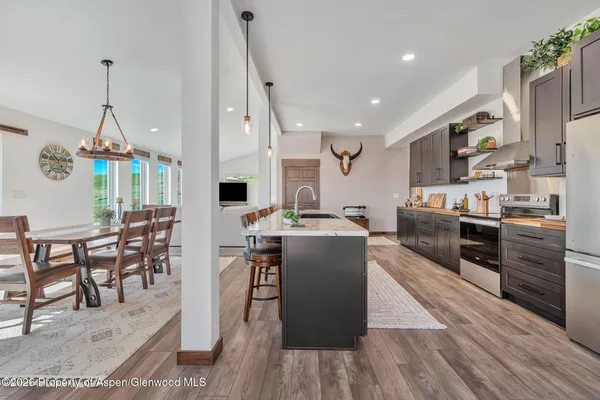 a large kitchen with stainless steel appliances kitchen island granite countertop a large counter top and wooden floors