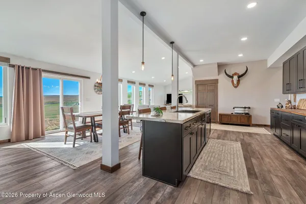 a large kitchen with stainless steel appliances granite countertop a lot of counter space and wooden floor