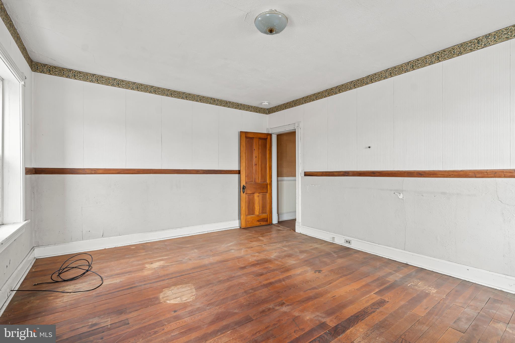 767 Spruce Street Hagerstown, MD 21740 - Photo 19 of 36 a view of an empty room with wooden floor and a window