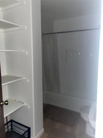 an empty room with a fan & a ceiling fan