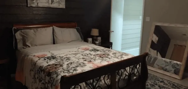 a bed sitting in a bedroom next to a window with wooden floor